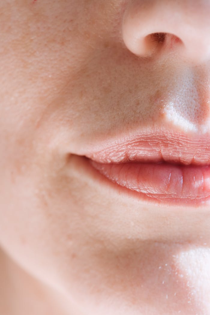 Intimate close-up of feminine lips with soft natural light highlighting the skin texture.